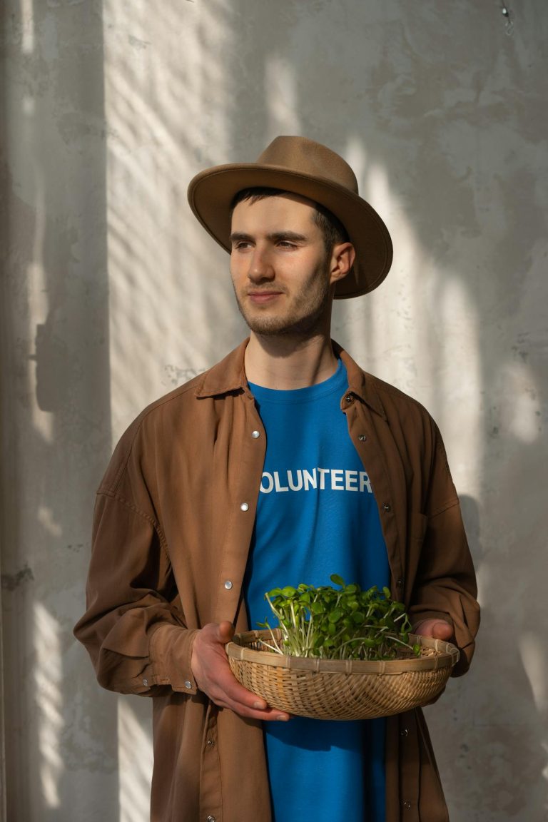 Caucasian man volunteering, holding seedlings, promoting environmental care.